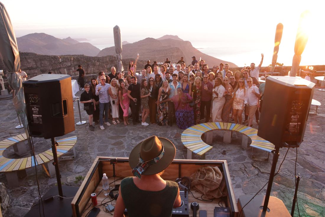 Nomads at a rooftop party with Table Mountain behind them